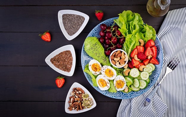 plate-with-paleo-diet-food-boiled-eggs-avocado-cucumber-nuts-cherry-strawberries-paleo-breakfast-top-view