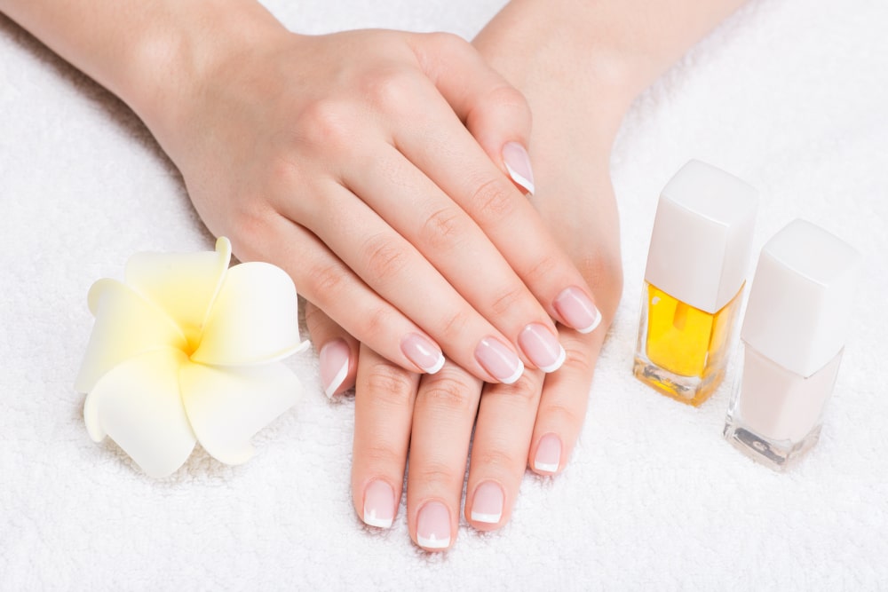 gel-nail-cleanser-with-white-back-ground-and-white-flower-french-manicure