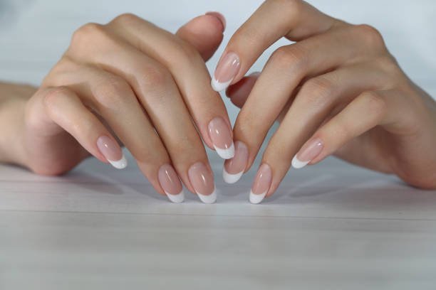 beautiful female hands french manicure with white tips nails