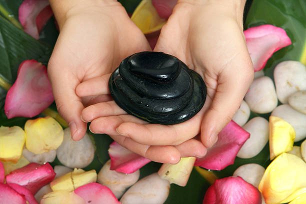 hot stone manicure, hands on petals and stones