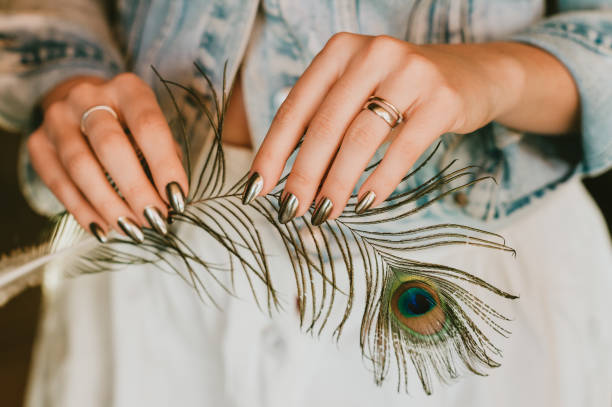 stylish trendy mirror manicure nail art holding peacock feather