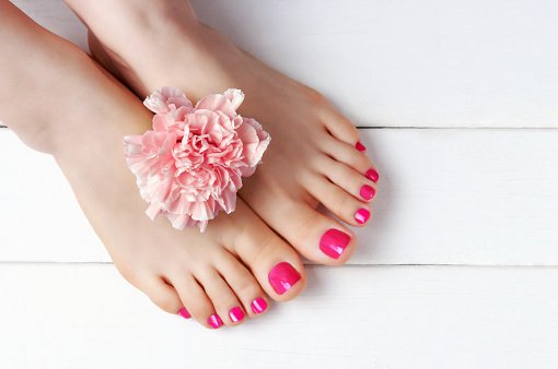 waterless pedicure pink nail polish on white wooden background