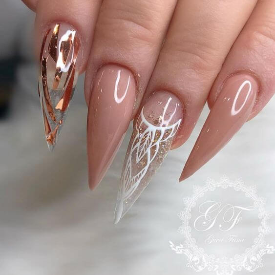 glassy long pointy nude nails with white and golden art